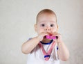 Little baby playing with toys. Small child chews on a toy