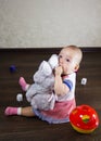 Little baby playing with toys. Small child chews on a toy