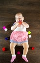 Little baby playing with toys. Small child chews on a toy