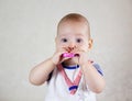 Little baby playing with toys. Small child chews on a toy