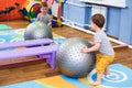 Little baby plays with a fitball in the gym Royalty Free Stock Photo