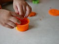 Little baby`s hands collecting and putting playdough back into the box, after finish playing Royalty Free Stock Photo