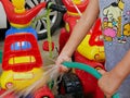 Little baby`s hands playing water and learning to wash plastic big bikes