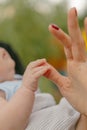 A little baby`s pen holds on to his mother`s finger Royalty Free Stock Photo