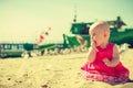 Little baby sitting trying eat sand