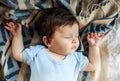 Little baby sleeping calm in bed at home, blue and white blanket background