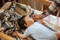 Little baby sleeping calm in bed at home, mother holding the hand, blue and white blanket background