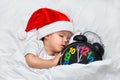 Little baby sleeping on white linen in the Santa hat and alarm show five minutes to eleven Royalty Free Stock Photo