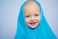 Little baby smiling under a white towel. Small little cute sweet blonde boy bathes in a bath. Royalty Free Stock Photo