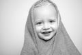 Little baby smiling under a white towel. Small little cute sweet blonde boy bathes in a bath. Royalty Free Stock Photo