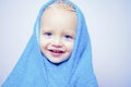 Little baby smiling under a white towel. Small little cute sweet blonde boy bathes in a bath. Royalty Free Stock Photo