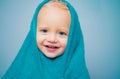 Little baby smiling under a white towel. Small little cute sweet blonde boy bathes in a bath. Royalty Free Stock Photo