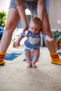 Little baby takes the first steps with the support of the mother, the child learns to walk, trainin Royalty Free Stock Photo