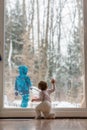 Little baby watching a sibling playing in snow Royalty Free Stock Photo