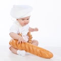 Little baker baby girl with a long loaf and bagels