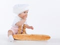 Little baker baby girl with a long loaf and bagels.