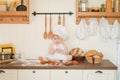 Little baker child in chef hat at kitchen table alone Royalty Free Stock Photo