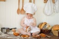 Little baker child in chef hat at kitchen table alone Royalty Free Stock Photo