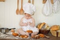 Little baker child in chef hat at kitchen table alone Royalty Free Stock Photo