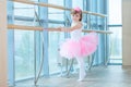 Little ballerina girl in a pink tutu. Adorable child dancing classical ballet in a white studio. Children dance. Kids