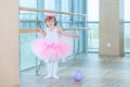 Little ballerina girl in a pink tutu. Adorable child dancing classical ballet in a white studio. Children dance. Kids