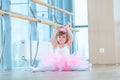 Little ballerina girl in a pink tutu. Adorable child dancing classical ballet in a white studio. Children dance. Kids