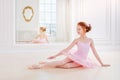 Little ballerina girl in a pink tutu and pointe shoes posing in white studio Royalty Free Stock Photo