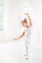 Little ballerina girl in a tutu. Adorable child dancing classical ballet in a white studio. Royalty Free Stock Photo