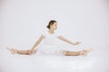 Girl ballet dancer in white dress against white background Royalty Free Stock Photo