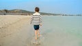 Little barefoot boy running on sandy sea beach and splashing water. Concept of kids traveling, joy, fun, happiness, holiday, Royalty Free Stock Photo