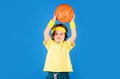 Little basketballer throwing basketball ball. Sportive child boy in uniform playing basketball. Professional sport Royalty Free Stock Photo