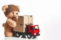 Little bear stacks cardboard boxes on a truck. Place for text. Royalty Free Stock Photo