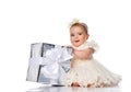 Little baby girl holding a big gift box in her hands on a white background. Royalty Free Stock Photo