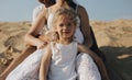 The little beautiful caucasian girl standing between her parents legs. Pregnant mother. Happy family in whote clothes Royalty Free Stock Photo