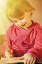 Little beautiful child girl learns to write outdoors preschool, development, training, education concept