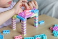 Small cute preschooler girl playing with colorful toy building blocks, sitting at the table Royalty Free Stock Photo