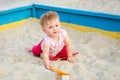 Little beautiful girl baby play in the sandbox and sand toys on the playground Royalty Free Stock Photo