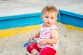 Little beautiful girl baby play in the sandbox and sand toys on the playground Royalty Free Stock Photo