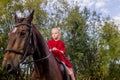 A little beautiful girl in a barnyard walks with a horse, Royalty Free Stock Photo