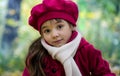 A little beautiful girl with big eyes, looks surprised, warm in autumn, in a pink beret and coat. Royalty Free Stock Photo