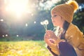 Little beautiful girl blowing dandelion on the meadow at sunset Royalty Free Stock Photo