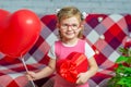 Little beautiful girl in glasses with red gift box heart and balloon. Valentine's Day holiday. Children's love. Child Royalty Free Stock Photo