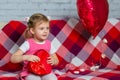Little beautiful girl in glasses with red gift box heart and balloon. Valentine's Day holiday. Children's love. Child Royalty Free Stock Photo