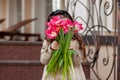 Little beautiful girl holding a beautiful festive bouquet of fresh pink tulips, covering her face with them. Young girl giving