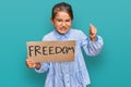 Little beautiful girl holding freedom banner annoyed and frustrated shouting with anger, yelling crazy with anger and hand raised