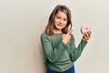 Little beautiful girl holding tasty colorful doughnut smiling happy pointing with hand and finger Royalty Free Stock Photo