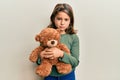 Little beautiful girl hugging teddy bear depressed and worry for distress, crying angry and afraid Royalty Free Stock Photo
