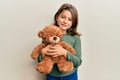 Little beautiful girl hugging teddy bear smiling with a happy and cool smile on face Royalty Free Stock Photo