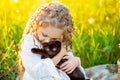 Little beautiful girl hugs a black kitten on the lawn in summer Royalty Free Stock Photo