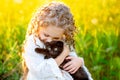 Little beautiful girl hugs a black kitten on the lawn in summer Royalty Free Stock Photo